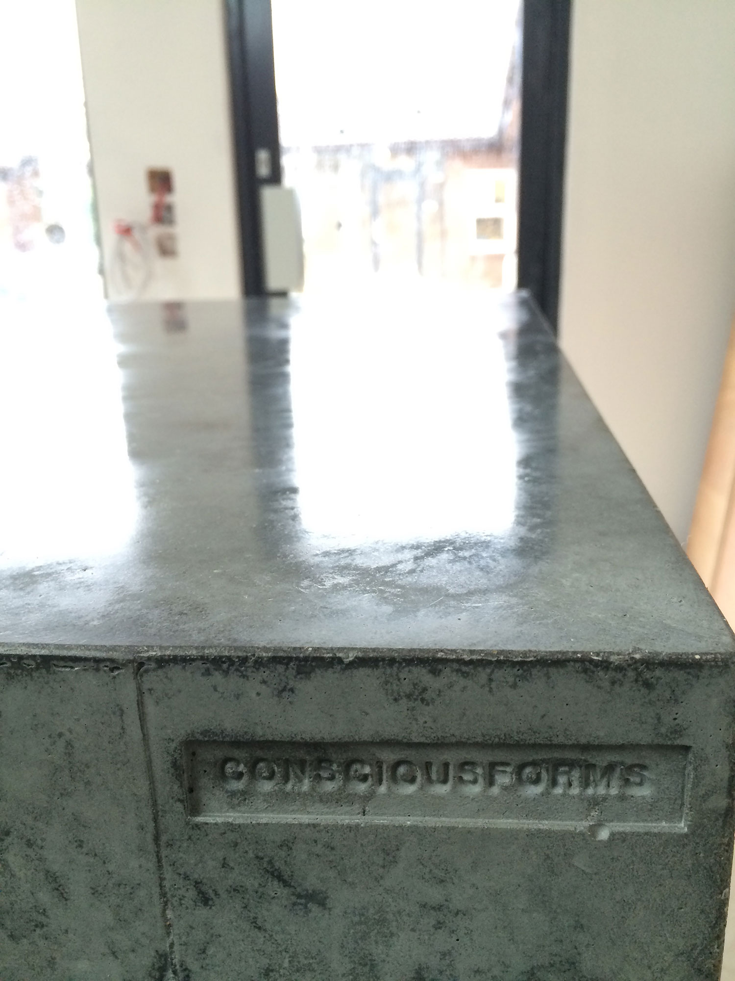 Conscious Forms - st raphaels hospice cheam orangery cafe polished concrete service counter standard grey cementitious finish before exposed aggregate finish consciousforms embossed logo